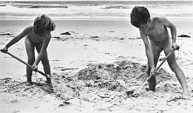 Two kids digging in the sand