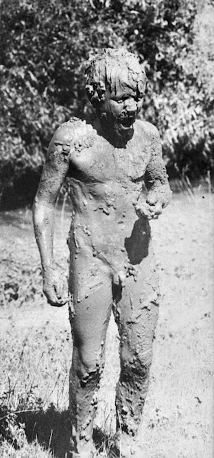 A boy covered in thick mud