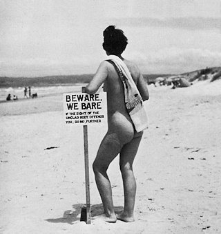 Woman leaning on warning sign